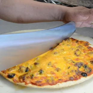 a person cutting a pizza