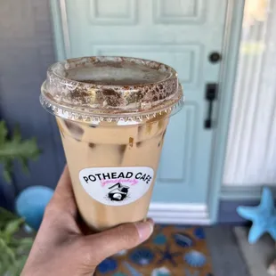 a hand holding a cup of iced coffee
