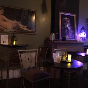 a candle lit room with a painting on the wall