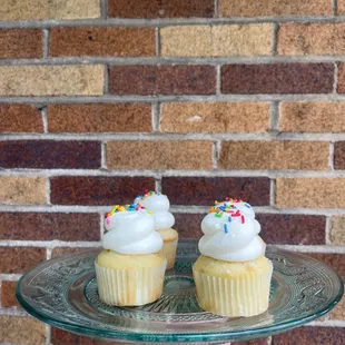 two cupcakes on a glass plate