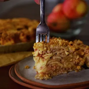 a person holding a fork over a piece of pie