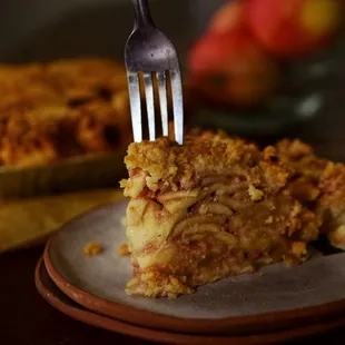 a person holding a fork over a piece of pie