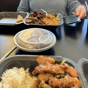 a woman sitting at a table with plates of food