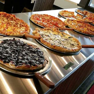 a variety of pizzas on a table