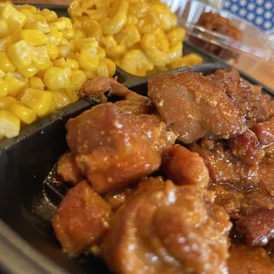 a plate of meat and corn on a table