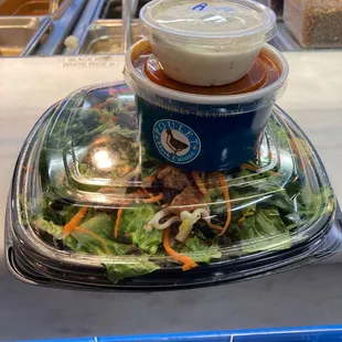 a salad in a plastic container on a table
