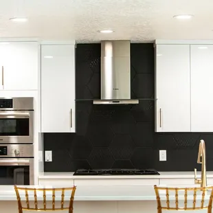 Custom black backsplash on top of glossy white cabinets