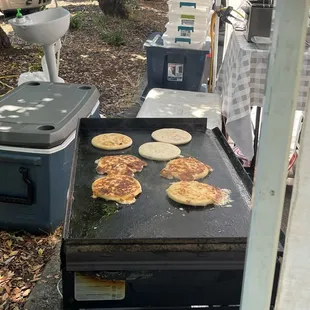 pancakes cooking on a griddle