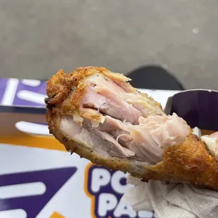 a hand holding a chicken sandwich
