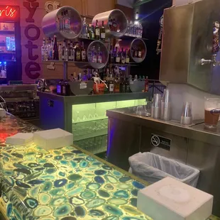 a bar with a counter and a neon sign