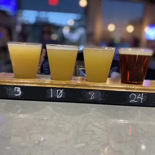 four glasses of beer on a bar