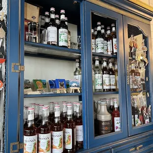 a blue china cabinet filled with drinks