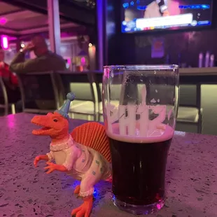 a dinosaur and a glass of beer