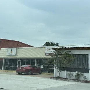 a red car parked in front of a coffeehouse