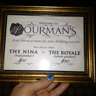 a hand holding a framed sign