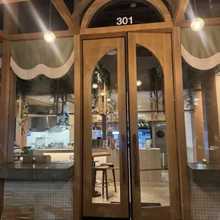 Entry door to Manny&apos;s. The door to Powder Room is the back right gray door with the black circle in the middle.