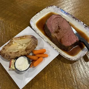 a plate of meat, potatoes and carrots