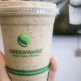 a hand holding a cup of greenware