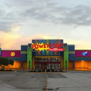 an empty parking lot in front of a brightly lit building