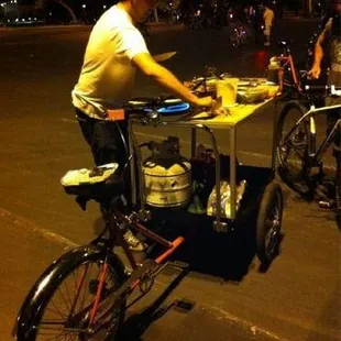 a man on a bicycle with a cart of food