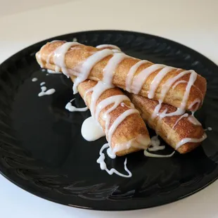 two doughnuts on a black plate