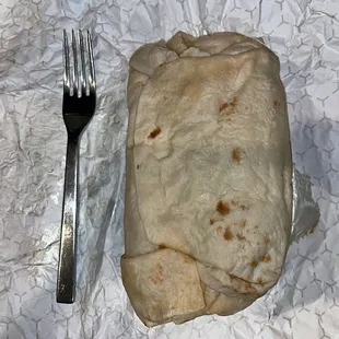 Beef Brisket Burrito next to fork for a size comparison (it&apos;s huge)