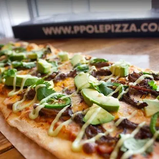 a pizza topped with avocado and other toppings