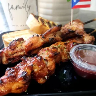 chicken skewers on a black plate