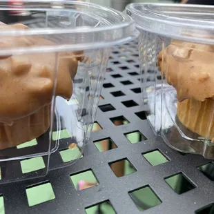 two muffins in plastic containers