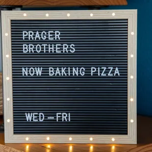 a sign that says now baking pizza wed - fri