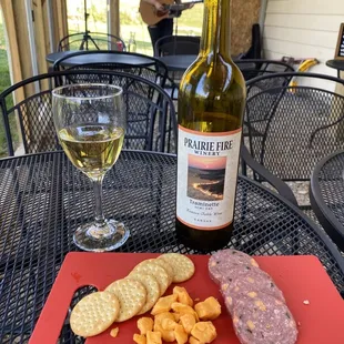 a glass of wine, crackers, and a bottle of wine