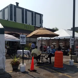 people sitting at tables under umbrellas