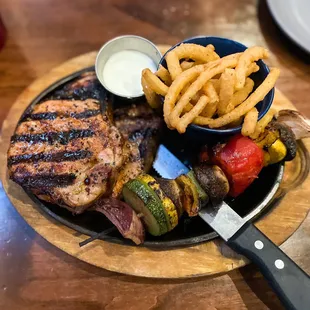 Grilled pork chops, onion strings, grilled veggie skewer