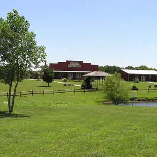 a view of a ranch with a pond in the foreground