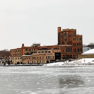 The brewery in the winter from across an icy Rock River