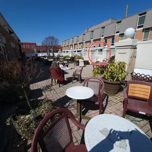 My wife is sitting at our table wearing a red coat. Entrance to exterior stairway is circled in red. My shadow on table.