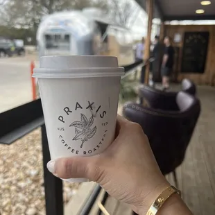 a hand holding a cup of coffee