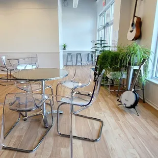 a table and chairs with a clock in the background