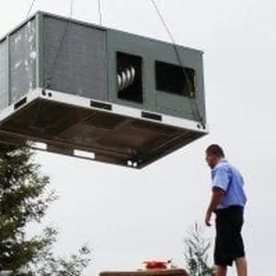 a man standing on a platform with a large air conditioner in the background