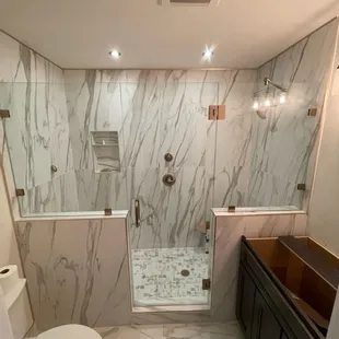 Frameless Shower Enclosure with Support Bar. Customer went with the Brushed Bronze Hardware and Standard Clear Glass. Very clean look.