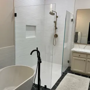 Frameless Shower Splash Panels in 1/2" Starphire Ultra Clear Glass and Matte Black Hardware.