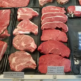 a variety of steaks in a display case