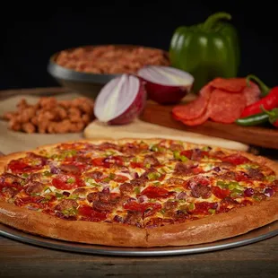 a pizza with pepperoni, onions, and peppers