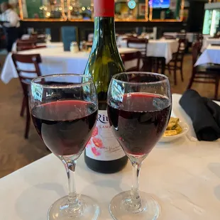 two glasses of wine and a bottle of wine