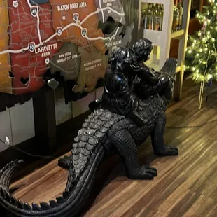 a statue of a godzilla in front of a map