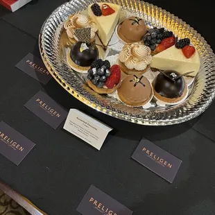 Selection of pastries, including lemon tart, fruit tart, cheesecake, chocolate raspberry domes, and chocolate hazelnut domes.
