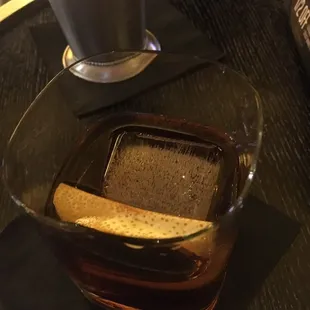 a glass of tea with a cracker in it