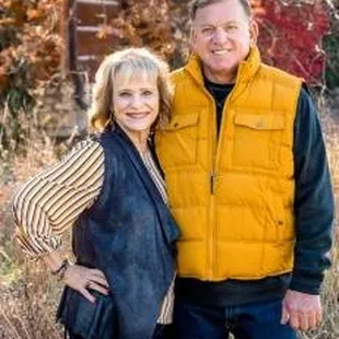 a man and woman standing in a field
