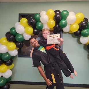 My son and his instructor celebrating his orange belt promotion.