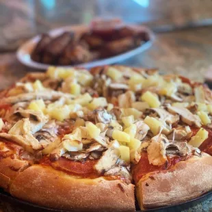 a pizza with pineapples and mushrooms